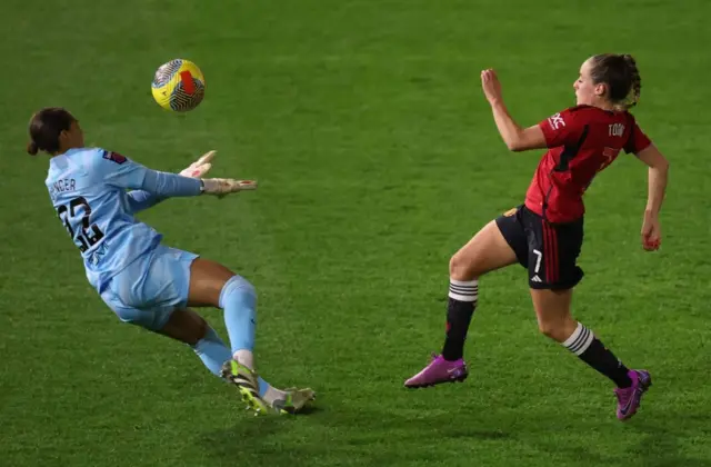 Ella Toone beast goalkeeper Rebecca Spencer to the ball