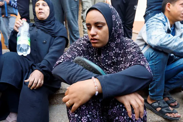 Razan Ashram holds her husband's shoes