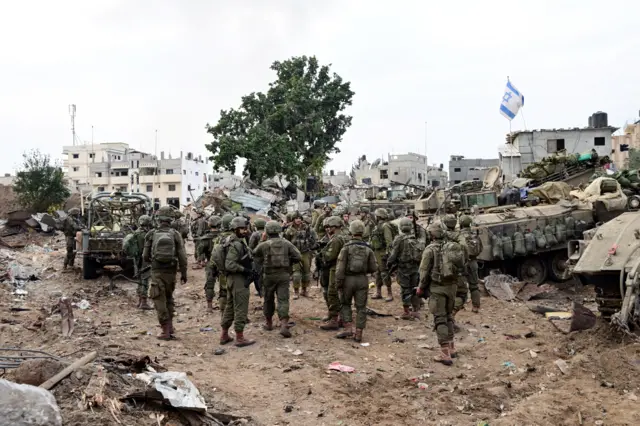 A group of Israeli soldiers walk through an urban area