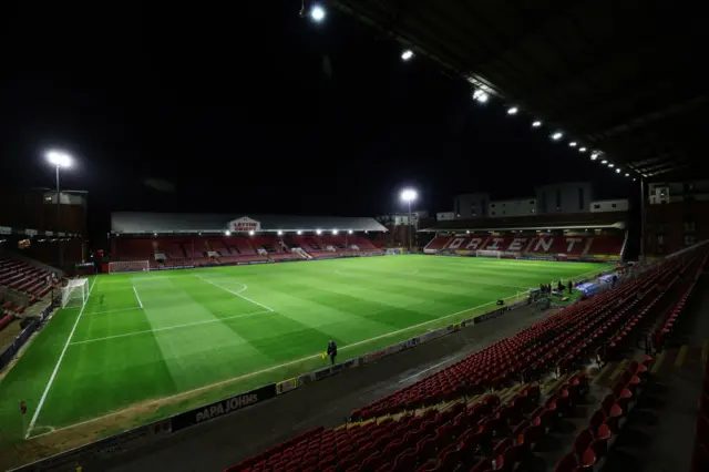 Brisbane Road stadium stands ready lit up by the floodlights.