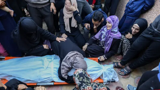 Palestinians mourn as they collect the bodies of people killed in an air strike, in Khan Younis (11 December 2023)