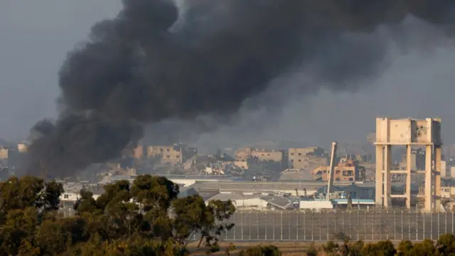 Smoke rises inside central Gaza strip following an air strike, amid the ongoing conflict between Israel and the Palestinian Islamist group Hamas, as seen from southern Israel, December 11, 2023.