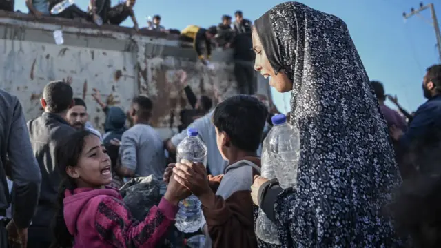 Palestinians flock to a truck carrying drinkable water, as they face the threat of hunger and thirst in Rafah, Gaza on December 11, 2023.