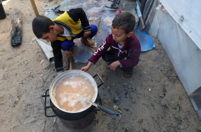 Away from the fighting, displaced Palestinian children, who fled their house due to Israeli strikes, shelter in a tent camp in Khan Younis