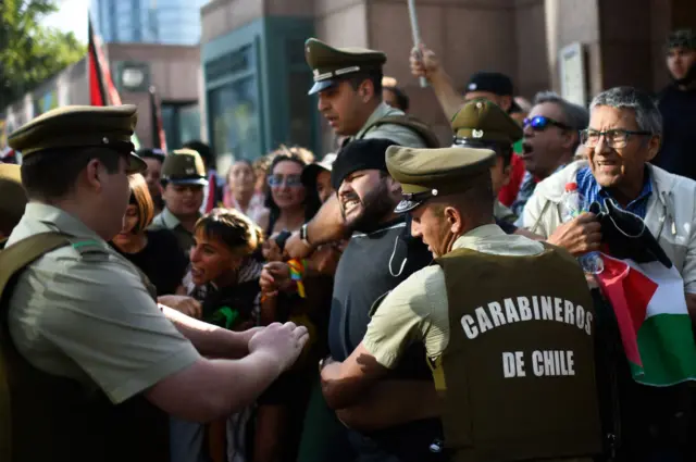 Chilean 'carabineros' confront demonstrators protesting with Palestinian flags in front of the US embassy to call for a ceasefire in the Gaza Strip, in Santiago, on December 11, 2023.