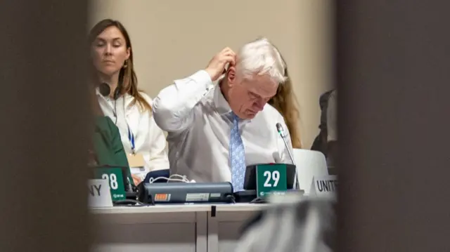 Long lens photo of Stuart at the negotiating table