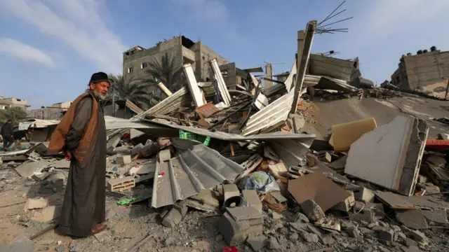 A Palestinian man inspects the damage at the site of Israeli strikes on houses, amid the ongoing conflict between Israel and the Palestinian Islamist group Hamas, in Khan Youni
