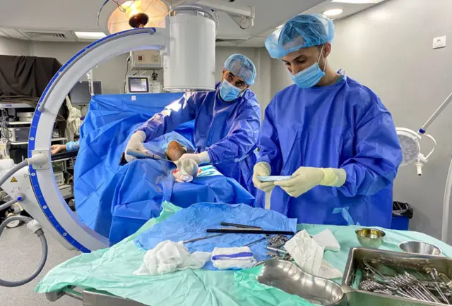 Doctors operate on a patient at Al-Awda Hospital, one of the last remaining functional hospitals in Northern Gaza on November 30, 2023.