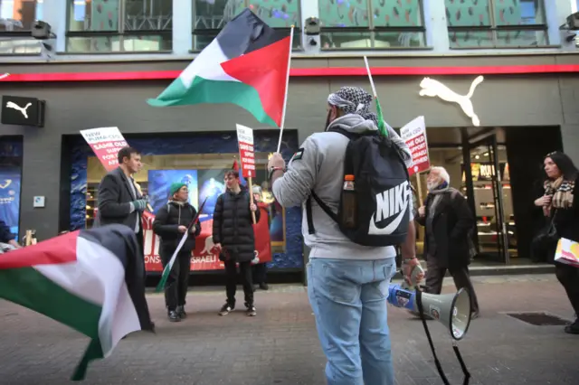 Protesters hold flags and signs asking shoppers to boycott Puma outside Pumas flagship Carnaby Street Store on January 21, 2023 in London. Palestinian Solidarity Campaign are calling on shoppers to boycott Puma goods as the company is one of the main sponsors of the Israeli Football Association (IFA).