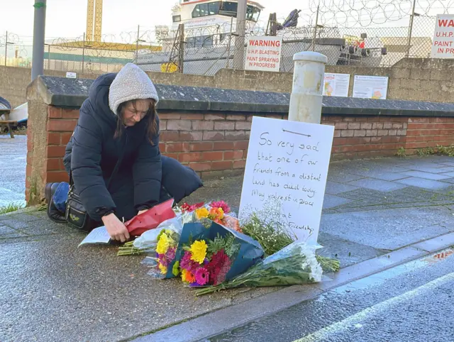 Resident laying a floral tribute