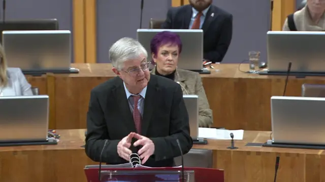 Dawn Bowden sitting behind the first minister as he answers questions on her conduct