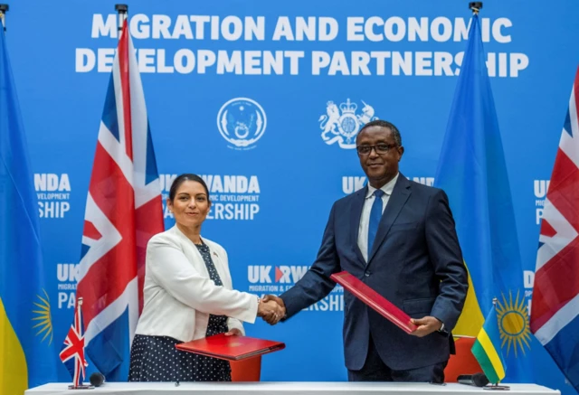 Priti Patel shakes hands with Rwandan Foreign Minister Vincent Birutaafter signing the partnership agreement at a joint news conference in Kigali, Rwanda, April 14, 2022.