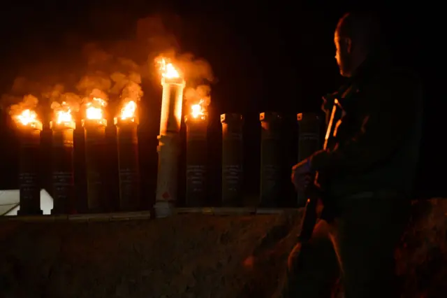 Soldiers light a menorah made out of artillery charge containers on the fifth night of Hanukkah