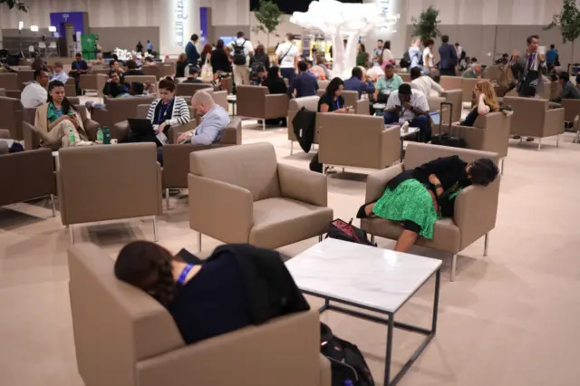 People rest in chairs in the COP28 conference centre