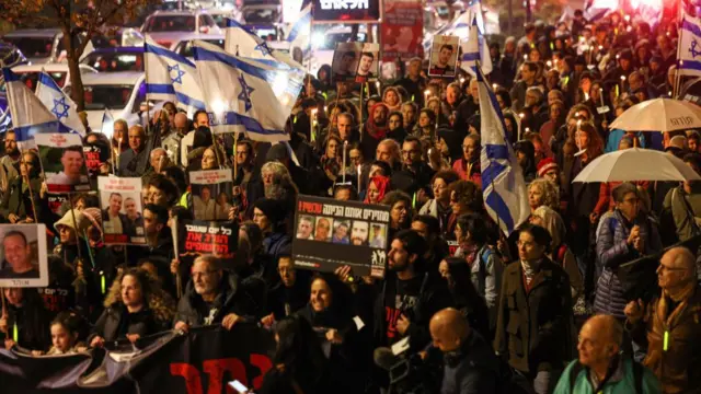 Protesters carry posters during a demonstration calling for the release of Israeli hostages held by Hamas since the October 7 attack, outside the israeli parliament in Jerusalem on December 12, 2023.