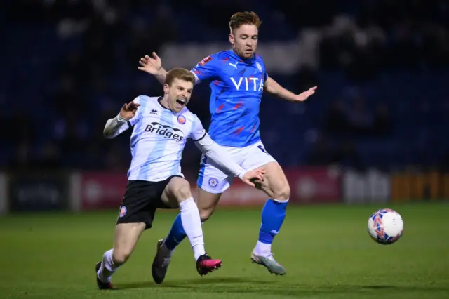 Stockport's Callum Camps (right) fouls Aldershot's Jack Barham