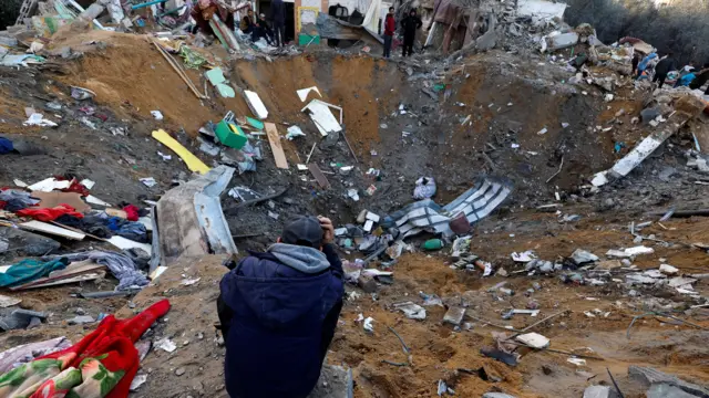 A Palestinian looks on at the site of Israeli strikes on houses amid the ongoing conflict between Israel and the Palestinian Islamist group Hamas, in Rafah in the southern Gaza Strip