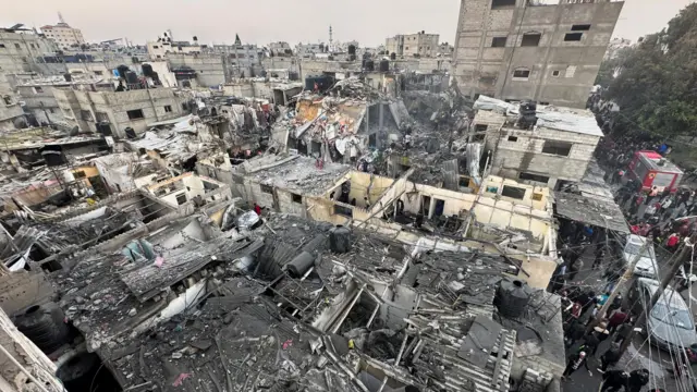 People search through the rubble of damaged buildings following an Israeli air strike on Palestinian houses, amid the ongoing conflict between Israel and the Palestinian Islamist group Hamas, in Rafah in the southern Gaza Strip December 12, 2023