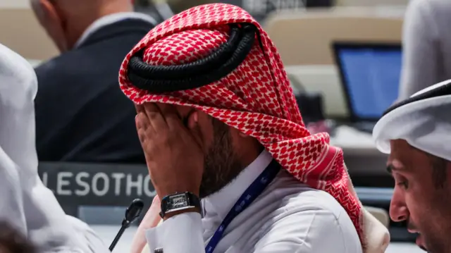 A delegate reacts ahead of a plenary meeting, after a draft of a negotiation deal was released, at the United Nations Climate Change Conference COP28 in Dubai, United Arab Emirates, December 13, 2023. REUTERS/Amr Alfiky