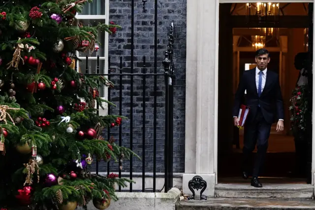 Prime Minister Rishi Sunak departs 10 Downing Street, with a Christmas tree in the foreground