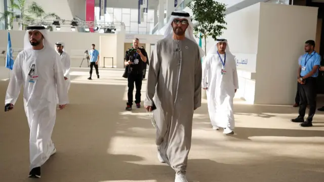 Sultan al-Jaber walks through the conference