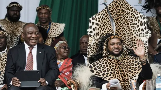 King Misuzulu Zulu, 48, waves to supporters as South African President Cyiril Ramaphosa looks on during the kings coronation at the Moses Mabhida Stadium in Durban on October 29, 2022.