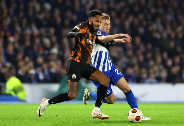 Pierre-Emerick Aubameyang of Marseille battles for possession with Jan Paul van Hecke of Brighton & Hove Albion