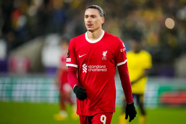 Darwin Nunez looks on wearing a Liverpool shirt and black gloves