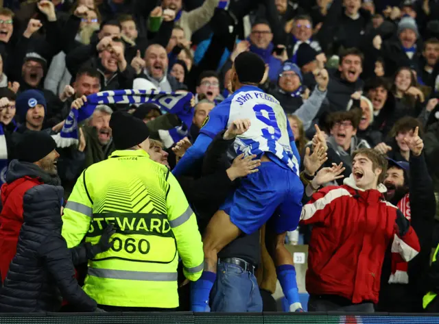 Brighton & Hove Albion's Joao Pedro celebrates by jumping into the crowd