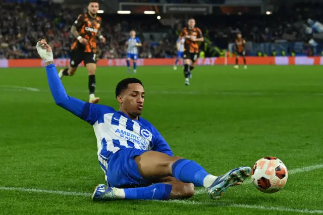 Joao Pedro slides to keep the ball in play for Brighton