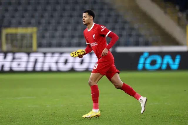 Cody Gakpo holds his right boot as he runs on the pitch