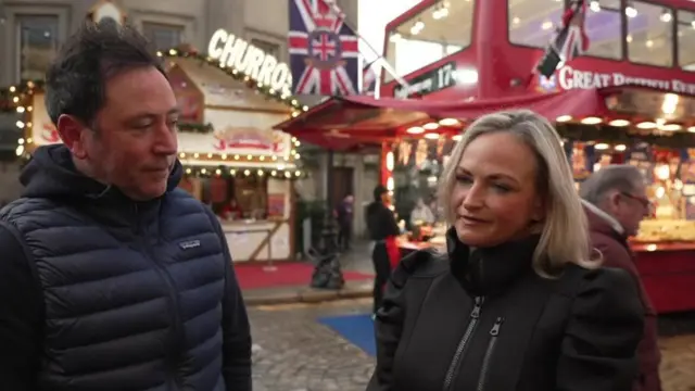 Two shoppers at Liverpool Christmas market speaking to the camera