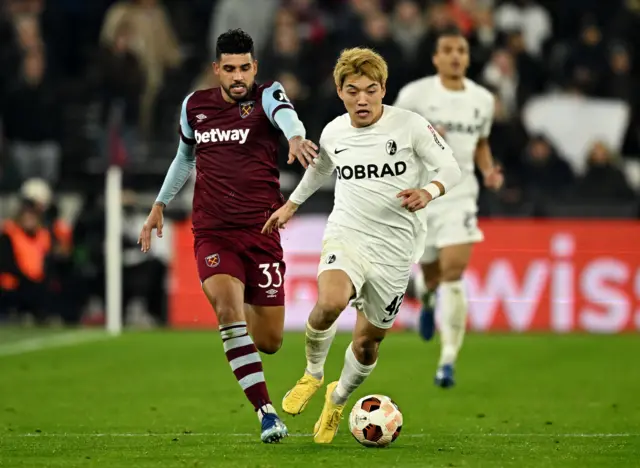 SC Freiburg's Ritsu Doan in action with West Ham United's Emerson Palmieri