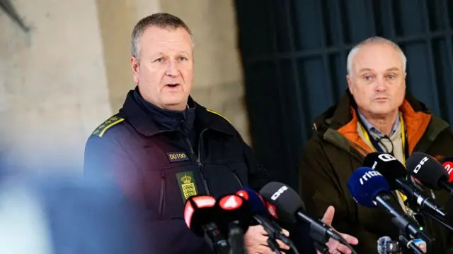 Danish police officers address reporters