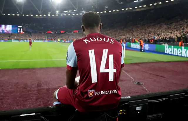 Mohammed Kudus of West Ham United celebrates by sitting on the advertisement hoardings