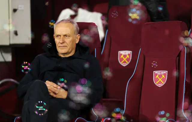 Christian Streich, Head Coach of Freiburg, sits in the dugout