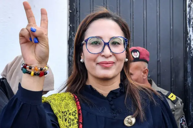 Chaima Issa, member of Tunisia's "National Salvation Front" opposition coalition, gestures as she arrives outside a military court in Tunis on October 3, 2023.