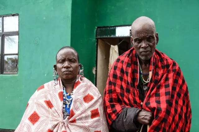 Nanyari Olekea (R) and his wife Ipaso Olekea, pose for a photo in front of their new house at the Msomera village in Handeni, Tanzania, on July 15, 2022