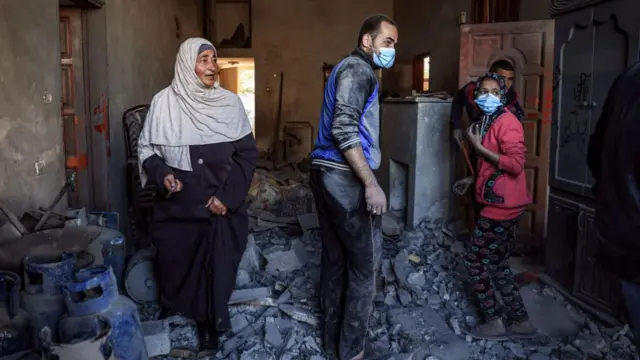 Palestinians check a heavily damaged house following Israeli bombardment on Rafah, in the southern Gaza Strip, on December 15, 2023,