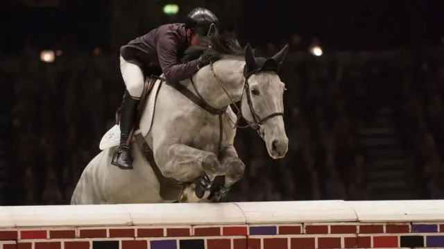 Great Britain's Guy Williams riding Mr Blue Sky in the Cayenne Puissance at the 2018 London International Horse show