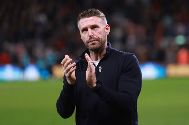 Rob Edwards, Manager of Luton Town, applaud the fans after coming out of the tunnel after the match is suspended