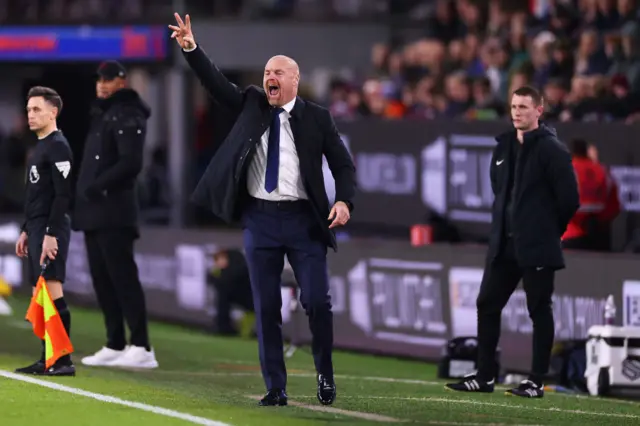 Dyche gestures a tactical tweak to his players on the sideline by hold up two fingers with his right hand.