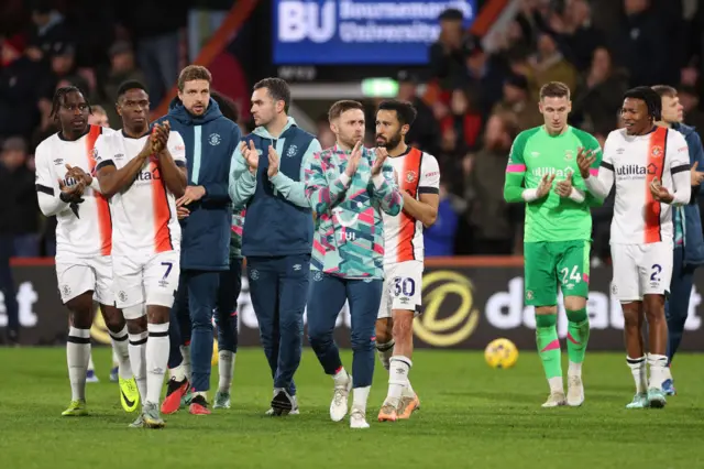 Players of Luton Town applaud the fans