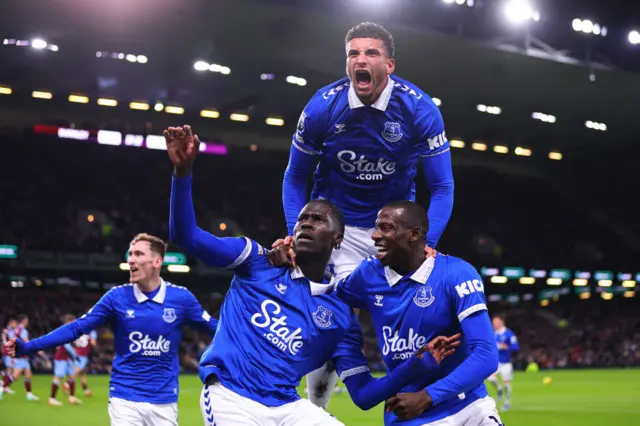 Everton players celebrate together in front of the travelling fans.