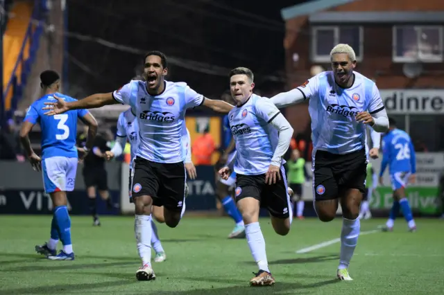 Aldershot players celebrate their FA Cup win against Stockport