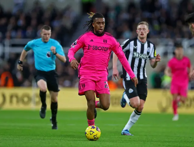 Fulham's Alex Iwobi in action with Newcastle United's Sean Longstaff