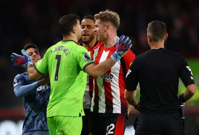 Aston Villa's Emiliano Martinez clashes with Brentford's Nathan Collins and Mathias Jorgensen