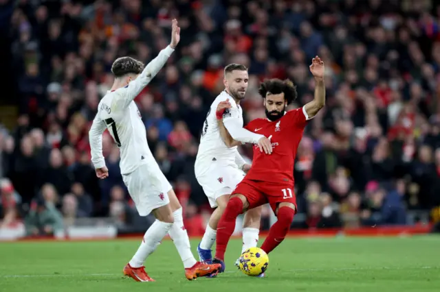 Mohamed Salah of Liverpool is challenged by Luke Shaw of Manchester United