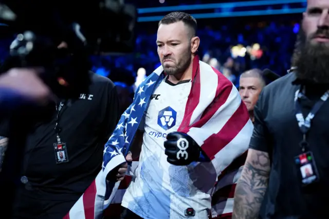 Colby Covington walks to the cage with the American flag