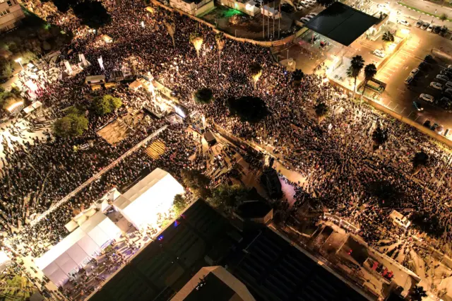 An aerial view of hundreds of people in the streets